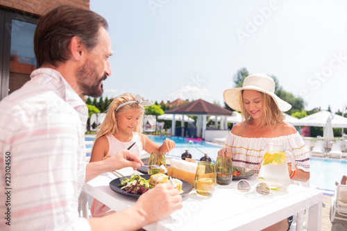 So delicious. Joyful positive family having their meal together while sitting at the table © Viacheslav Yakobchuk