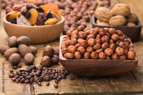 hazelnut nuts peeled raw in wooden bowl on table, grunge style.