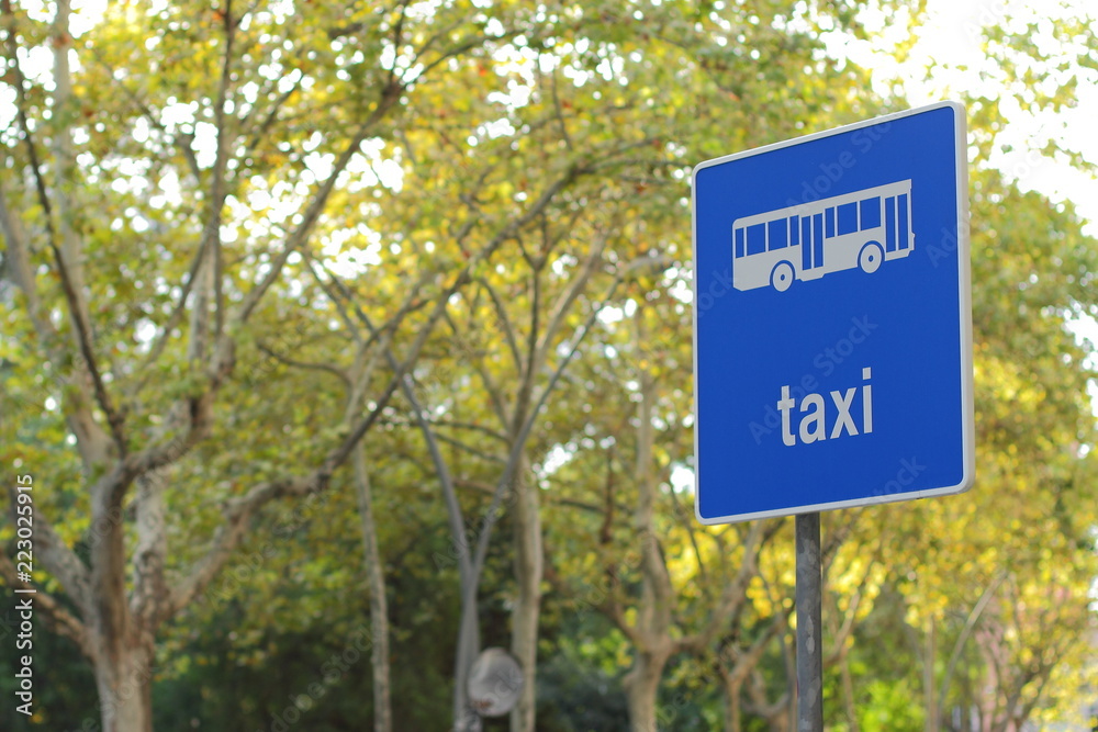 Editorial usage. taxi street sign in Barcelona on trees background , Spain, august 2018 
