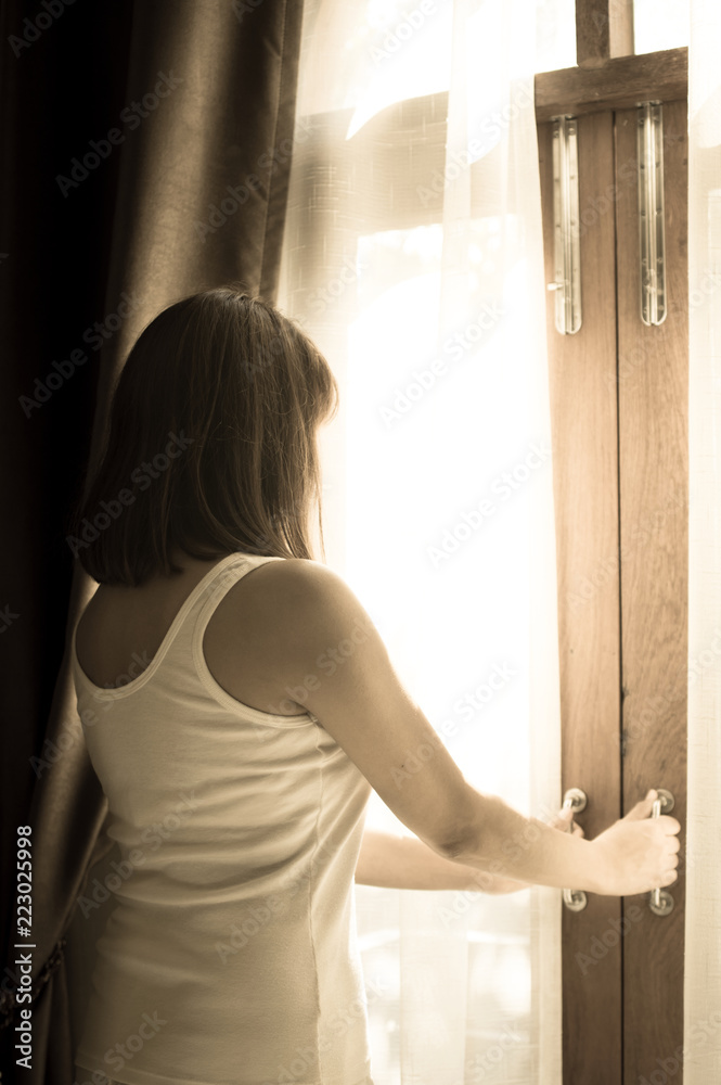 Sad Woman looking out and open window