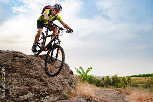 Fototapeta Naklejka Na Ścianę i Meble -  Cyclist Riding the Bike on Autumn Rocky Trail at Sunset. Extreme Sport and Enduro Biking Concept.