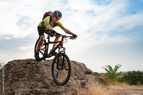 Cyclist Riding the Bike on Autumn Rocky Trail at Sunset. Extreme Sport and Enduro Biking Concept.