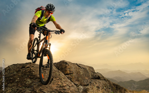 Cyclist Riding the Bike on Autumn Rocky Trail at Sunset. Extreme Sport and Enduro Biking Concept. photo