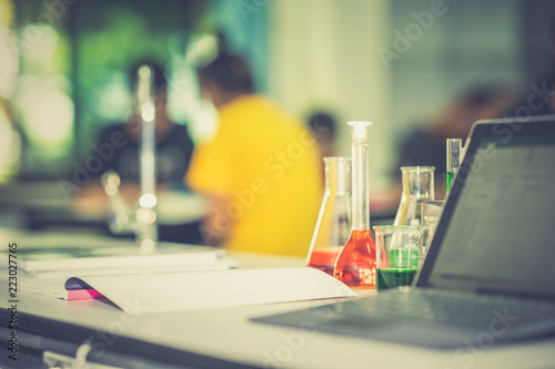Glassware chemical laboratory on table on blurred student learning and studying laboratory 