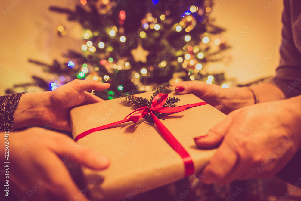 Fotografie Hands giving a christmas gift box