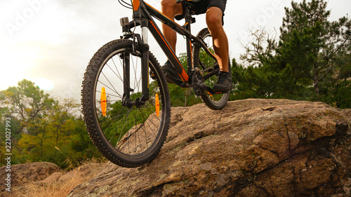 Cyclist Riding the Mountain Bike Down the Rock at Sunset. Extreme Sport and Enduro Biking Concept. © Maksym Protsenko