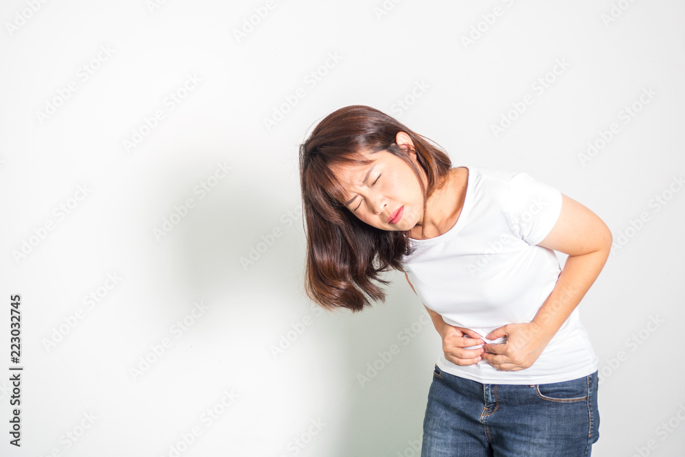 Asian adult woman stomachache. Hand holding tummy. Portrait on white background with copy space.. Asian adult woman stomachache. Hand holding tummy. Portrait on white background with copy space..
