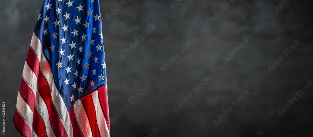 Obraz premium American flag freely hanging against a dark wall