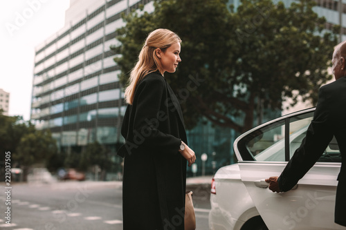 Foto Young businesswoman taking taxi