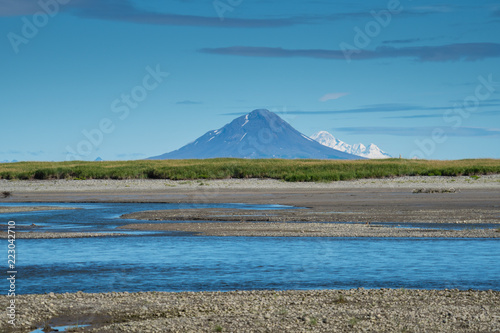 Beautiful view of Augustine Island, an active volcano near Katmai National Park. River with sandbars in foreground photo