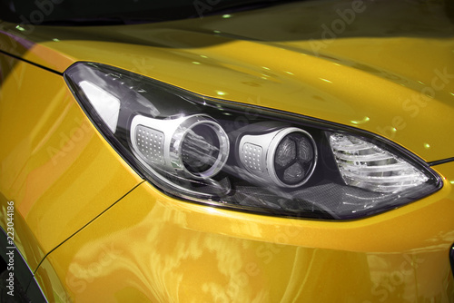 clean white headlight of a new yellow luxury car from the saloon. close-up of the front left headlight © Евгений Вдовин