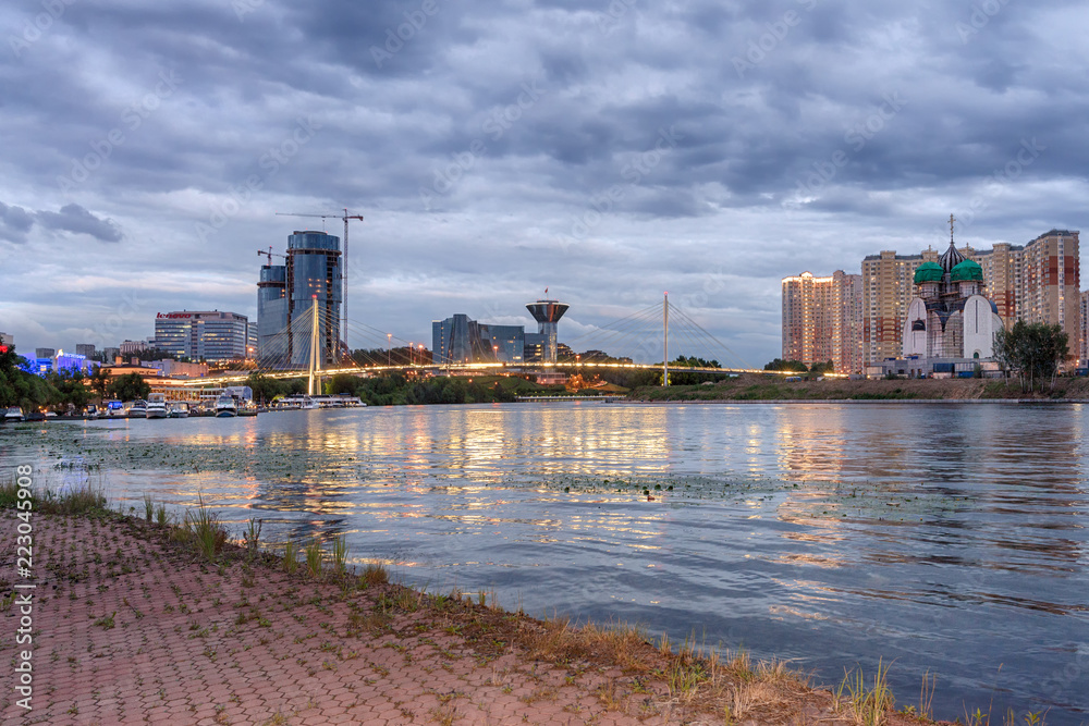 Naklejka premium Moscow region. July 6, 2018. Evening. Pavshinsky Bridge, the embankment of the Moskva River, Crocus City, the Government House, the Nikolsky Temple and the residential complex 
