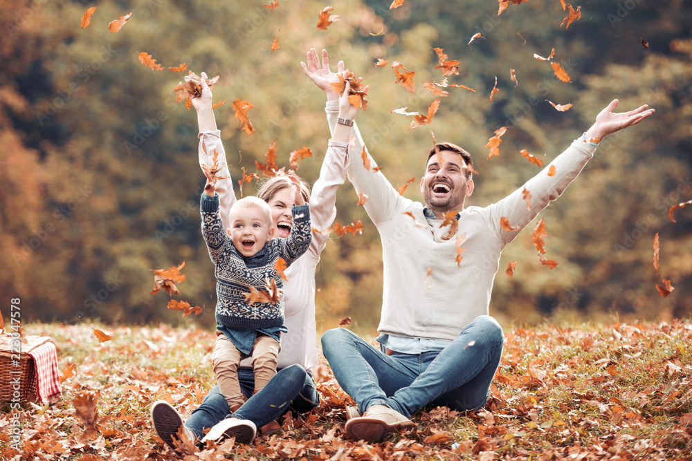 Happy family having fun in autumn forest - obrazy, fototapety, plakaty 