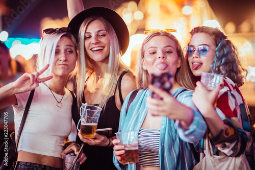 Group of female friends taking selfie at music festival 