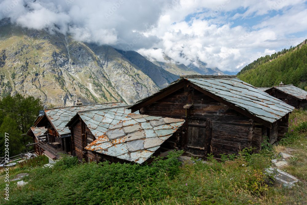 Old wooden mountain huts with stone plates for the roof near the Matterhorn