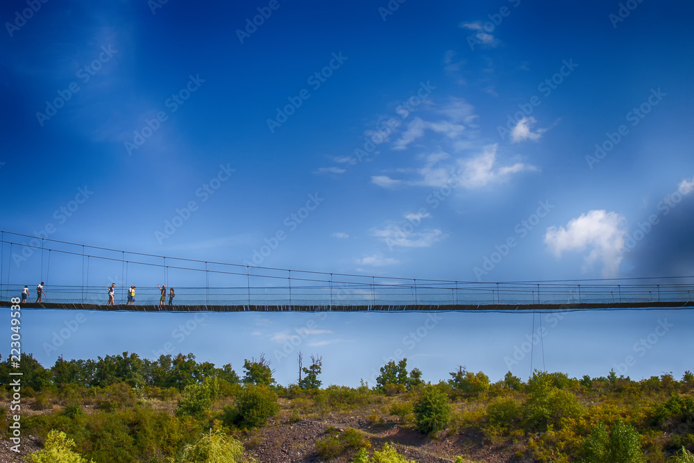 People walking on the suspension bridge over the trees in high height People walking on the suspension bridge over the trees in high height
