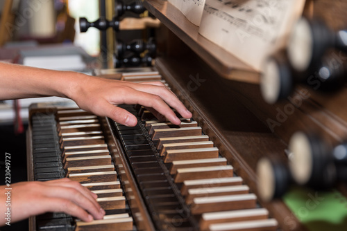 Person plays church organ - detail photo
