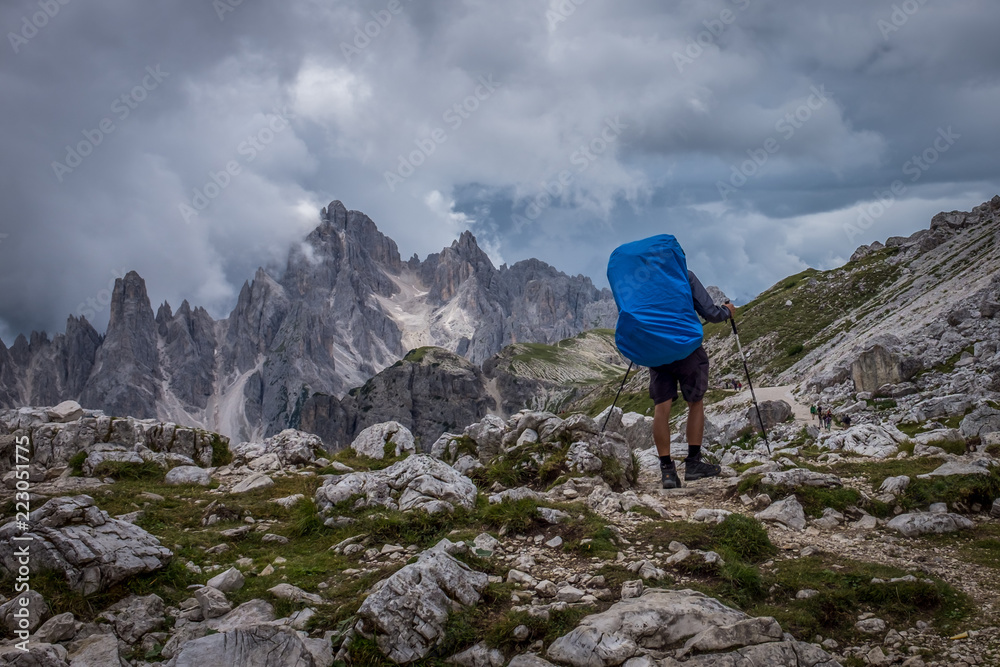 Trekker with backpack in the Italian Dolomites