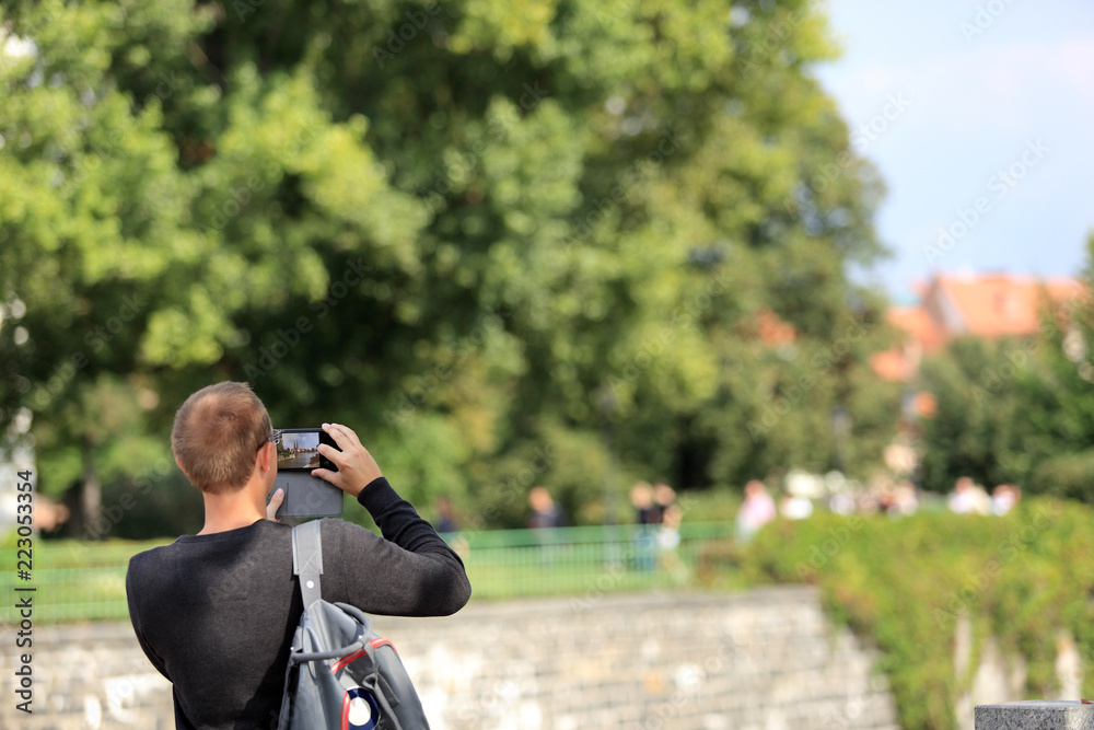 Mężczyzna z plecakiem robi zdjęcia telefonem komurkowym, smartfonem we Wrocławiu. Mężczyzna z plecakiem robi zdjęcia telefonem komurkowym, smartfonem we Wrocławiu.
