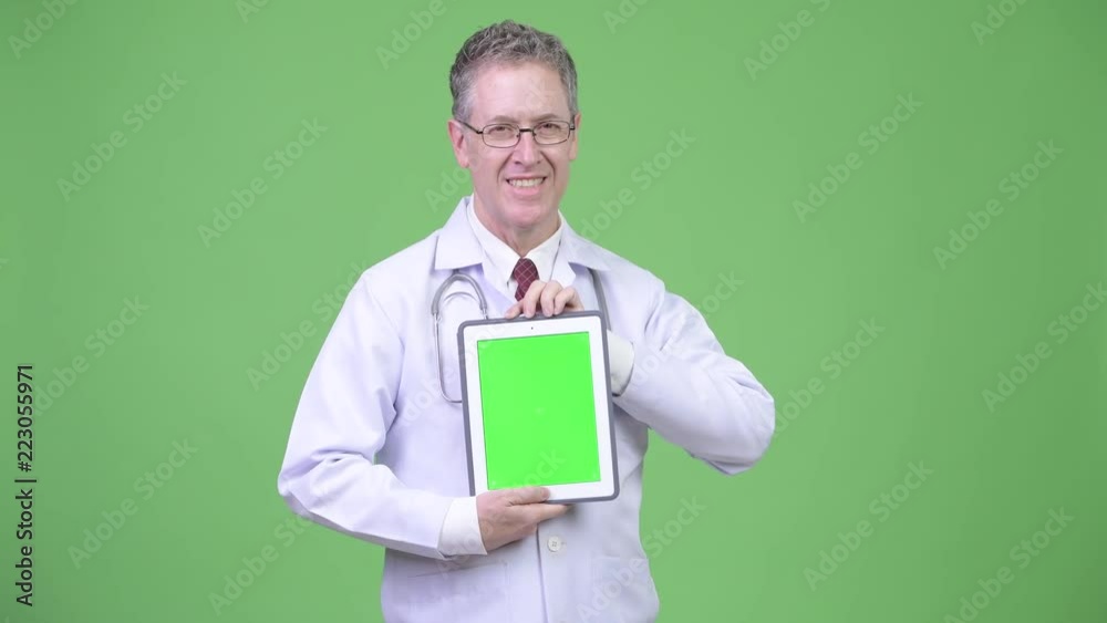 Portrait of happy mature man doctor showing digital tablet Portrait of happy mature man doctor showing digital tablet