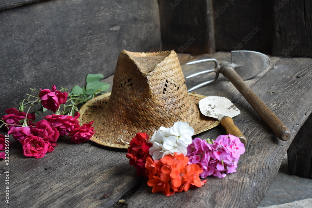 Sombrero de mimbre, flores recien cortadas y herramienta de jardinero Stock  Photo | Adobe Stock