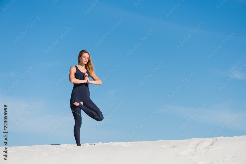 Tree yoga pose by young woman in desert Tree yoga pose by young woman in desert