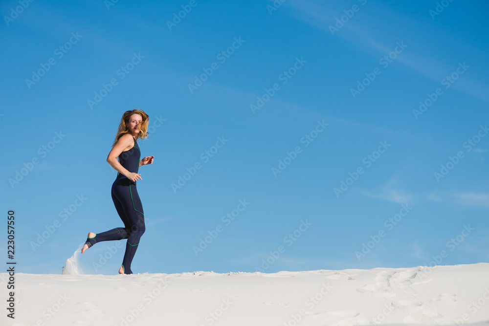 Woman running on sand in sport wear