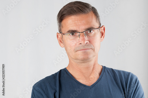 Portrait senior man in eyeglasses on gray background © unclepodger