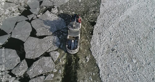 Aerial view of ferry that go through ice and leaving a trail. Footage of Helsinki city at spring. Finland