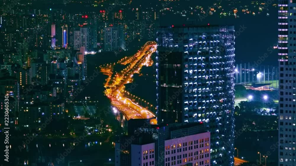 Abstract cityscape of night megalopolis with modern tall buildings or skyscrapers with flickering windows and cars moving on illuminated highway. Singapore nightlife. Speed motion video.