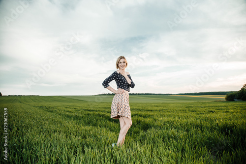 Young girl in a green field. Stylish girl. Green grass and blue sky. Emotional woman. plener. Travel. trip.