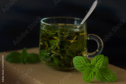 Green leaf tea on a dark background with mint leaves