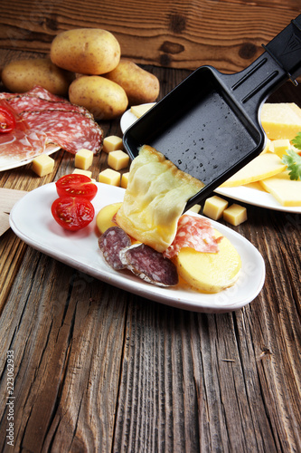 Photography Delicious traditional Swiss melted raclette cheese on diced boiled or baked potato