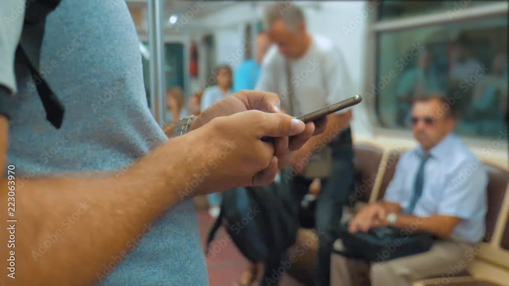 Casual traveler man reading from mobile phone smartphone writes messages screen while looks the navigator traveling on metro in the subway. slow motion video. Wireless internet on public transport Casual traveler man reading from mobile phone smartphone writes messages screen while looks the navigator traveling on metro in the subway. slow motion video. Wireless internet on public transport