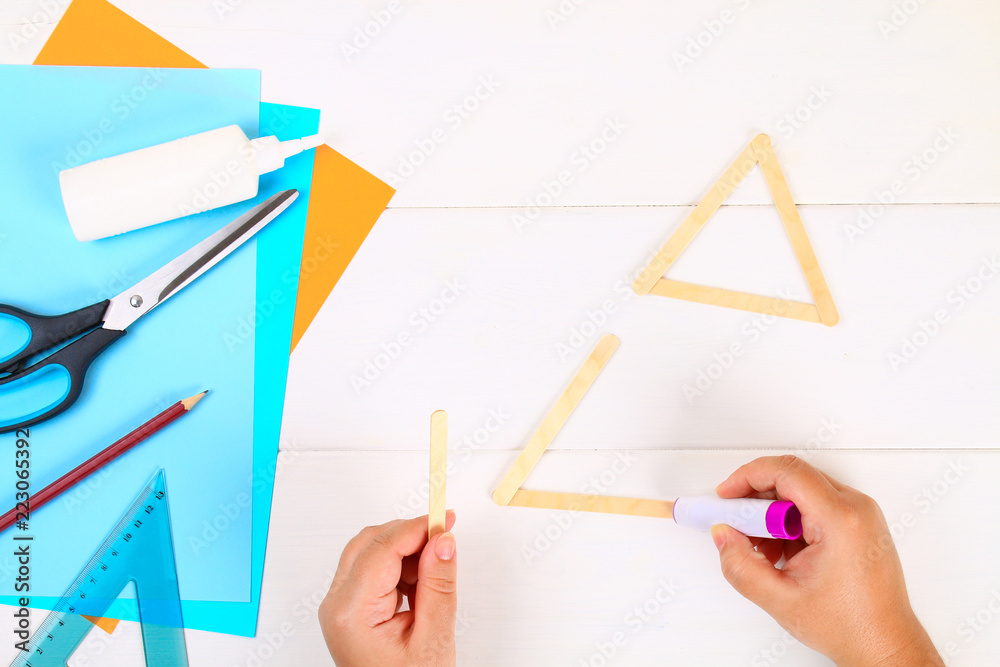 DIY. Star of David with his hands from ice cream sticks on a white wooden table. DIY. Star of David with his hands from ice cream sticks on a white wooden table.