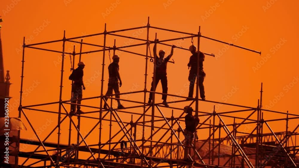 workers silhouette at sunset builders collect the design. construction workers concept building silhouette men lifestyle slow motion video group