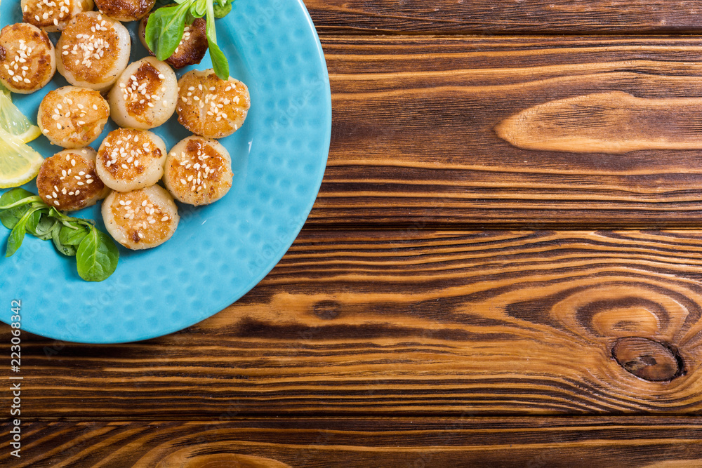 Fried scallops with lemon and salad Fried scallops with lemon and salad