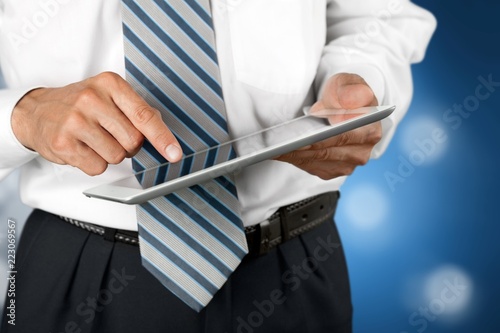 Businessman tapped on digital tablen on blurred background