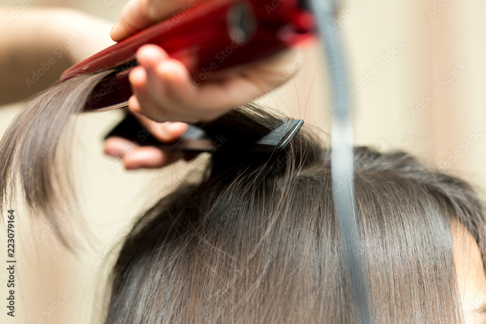 Naklejka premium wrap hair curling in a beauty salon