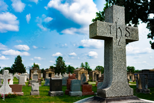 Ihs Cross on top of a Tombstone at a Cemetery