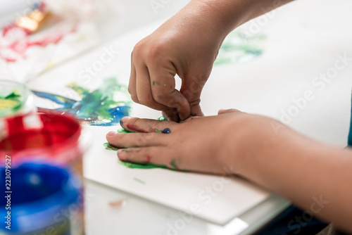 Closeup of toddler making palm print on paper