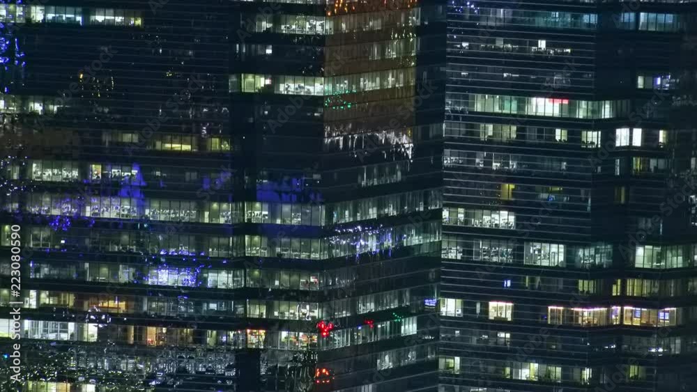 Abstract cityscape of night megalopolis with modern tall buildings or skyscrapers with flickering windows and glowing illumination. Singapore nightlife, beautiful Asian city