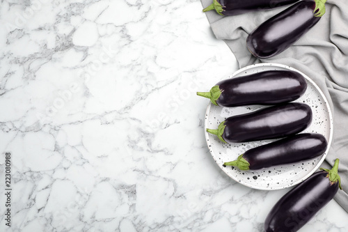 Raw ripe eggplants on marble background, top view