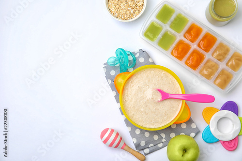 Flat lay composition with bowl of healthy baby food and space for text on white background