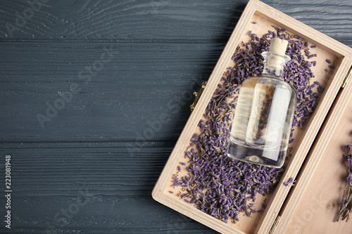 Fototapeta Naklejka Na Ścianę i Meble -  Flat lay composition with natural herbal oil and lavender flowers on wooden background. Space for text