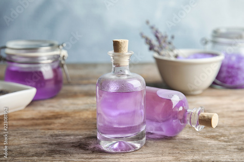 Fototapeta Naklejka Na Ścianę i Meble -  Bottles with natural lavender oil on table against blurred background