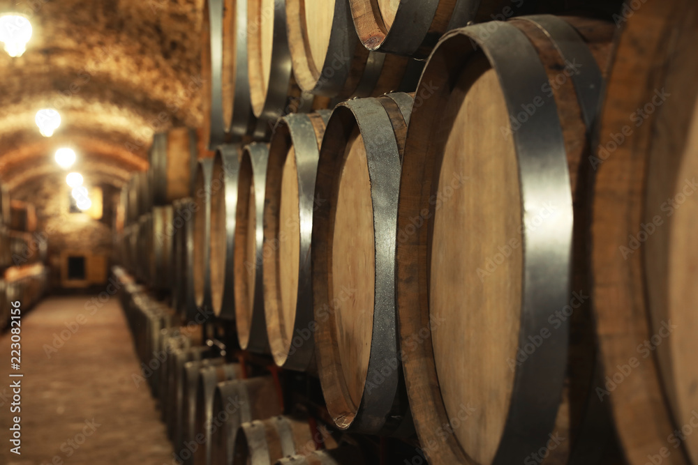 Large wooden barrels in wine cellar, closeup Large wooden barrels in wine cellar, closeup