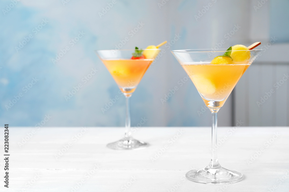 Glasses with tasty melon ball drink on table. Background with space for text