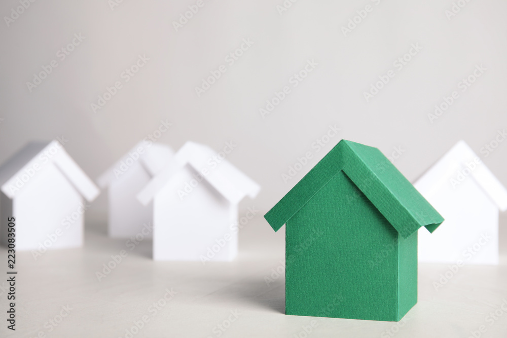 Green and white house models on light background
