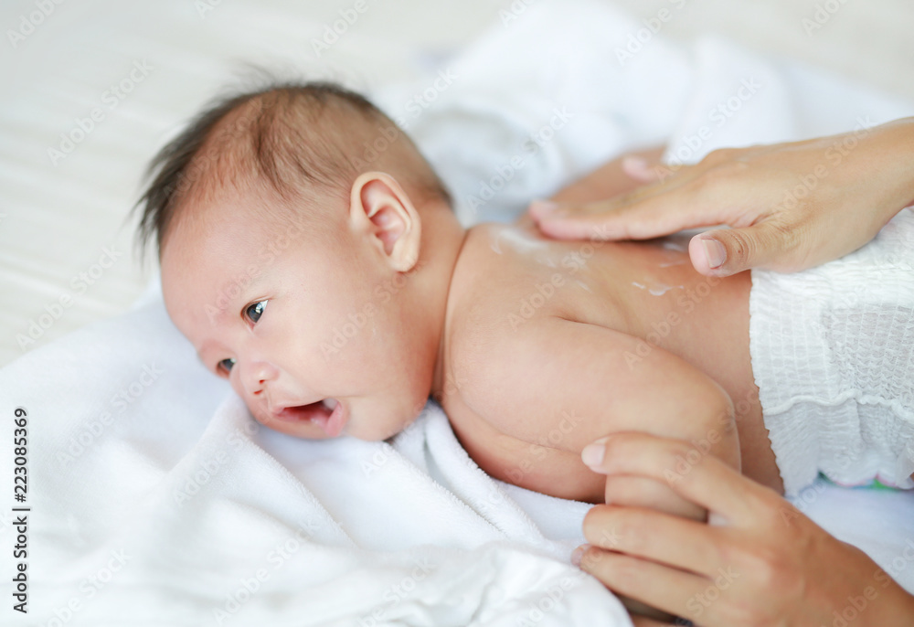 Mother are applying a lotion cream on the baby body after bath. Baby Care Concept. Mother are applying a lotion cream on the baby body after bath. Baby Care Concept.